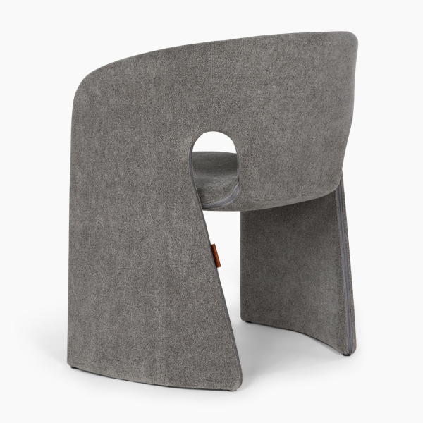 Three‑quarter rear view of grey Aether Pearl dining chair showing curved backrest and side cut-out design العربية: منظر خلفي جانبي ثلاثي الأبعاد لكرسي Aether Pearl الرمادي يُظهر مسند ظهر منحني وتصميم فتحة جانبية