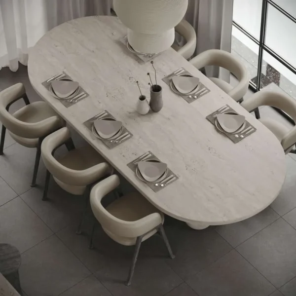 Top view of oval travertine dining table set for eight, ideal for luxury dining rooms in UAE homes. منظر علوي لطاولة طعام بيضاوية من الترافرتين معدة لثمانية أشخاص، مثالية لغرف الطعام الفاخرة في منازل الإمارات.