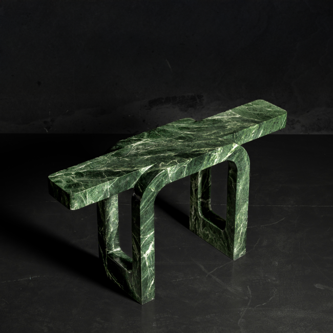 Striking green marble console table with sculptural arch-support legs, designed as a luxury furniture accent for modern interiors in the UAE. طاولة كونصول فاخرة من الرخام الأخضر بتصميم نحتي وأناقة عصرية – قطع أثاث راقية تناسب الديكورات الفاخرة في الإمارات. Sources