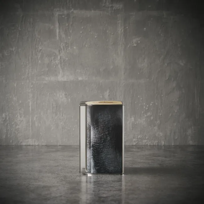 Ember side table in a minimalist setting, showcasing a charred wood core inside a transparent acrylic cube – modern UAE luxury furniture طاولة جانبية من طراز إمبر بتصميم مكعب في بيئة بسيطة، نواة خشبية محترقة داخل هيكل أكريليك شفاف – أثاث فاخر عصري في الإمارات