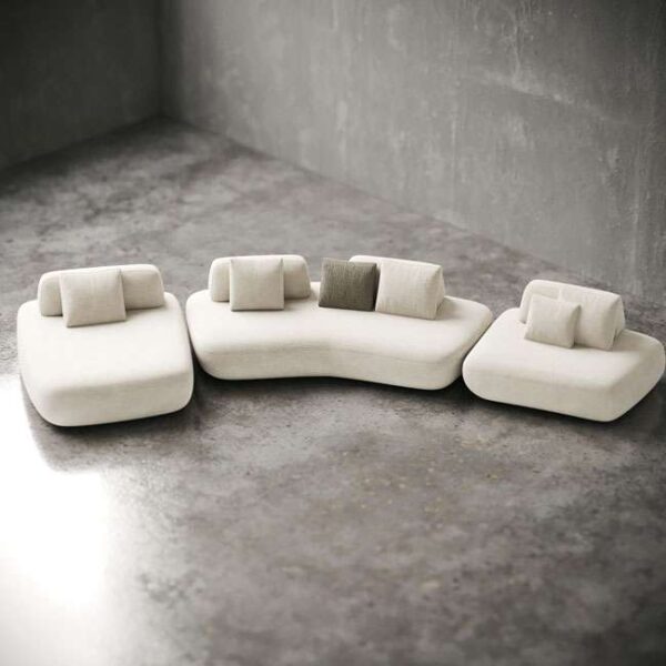 Top angle view of Sereno Sand Sofa showing modular arrangement with flowing lines and soft white tones. منظر علوي لكنبة سيرينو ساند يُظهر ترتيبها المكون من وحدات وخطوطها الانسيابية وألوانها البيضاء الناعمة.