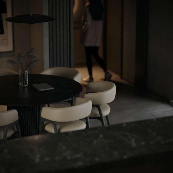 Statement round dining table with luxury dining chairs featuring soft upholstered seats and sleek wooden legs, showcased in a sophisticated modern space by Conceptual. Ideal for luxury villas, upscale apartments, and hospitality projects, this high-end dining furniture collection is designed for clients and interior designers seeking premium dining chairs in Dubai and Abu Dhabi, UAE.