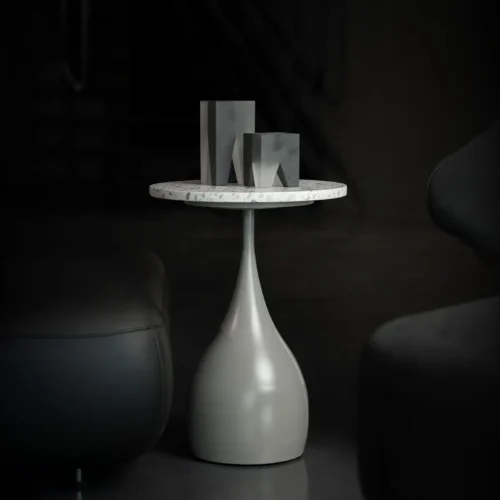 The Elara Slim Side Table features a slender, teardrop-shaped base in a smooth matte finish paired with a circular terrazzo top. Its elegant, elongated form brings a sense of sculptural lightness to any modern interior.