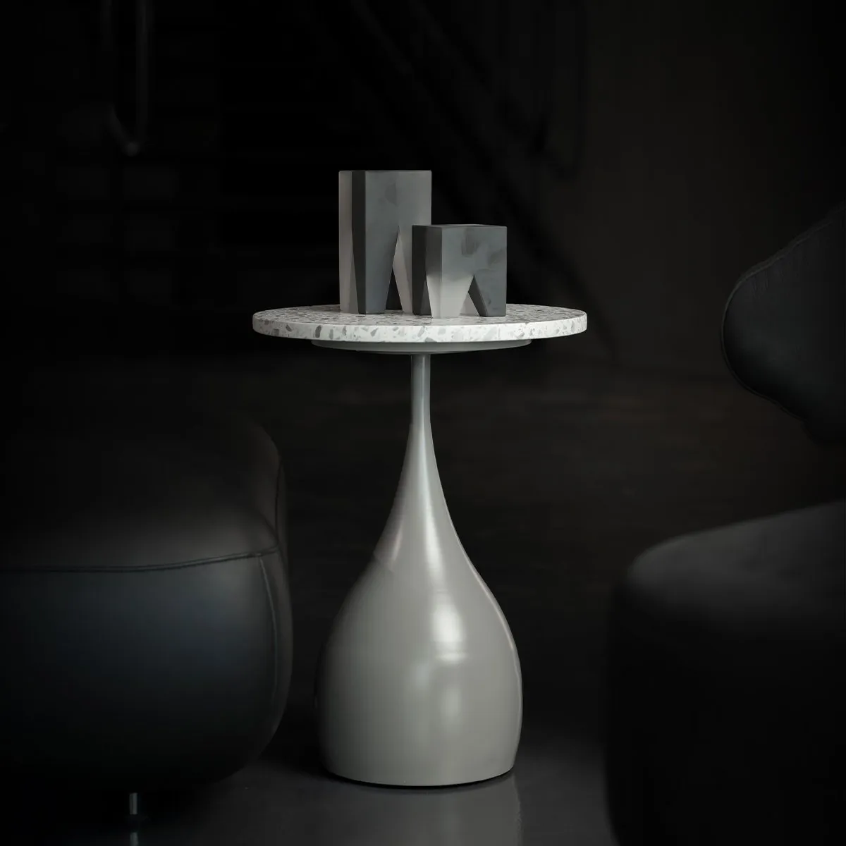 The Elara Slim Side Table features a slender, teardrop-shaped base in a smooth matte finish paired with a circular terrazzo top. Its elegant, elongated form brings a sense of sculptural lightness to any modern interior.