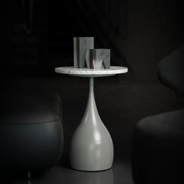 The Elara Slim Side Table features a slender, teardrop-shaped base in a smooth matte finish paired with a circular terrazzo top. Its elegant, elongated form brings a sense of sculptural lightness to any modern interior.