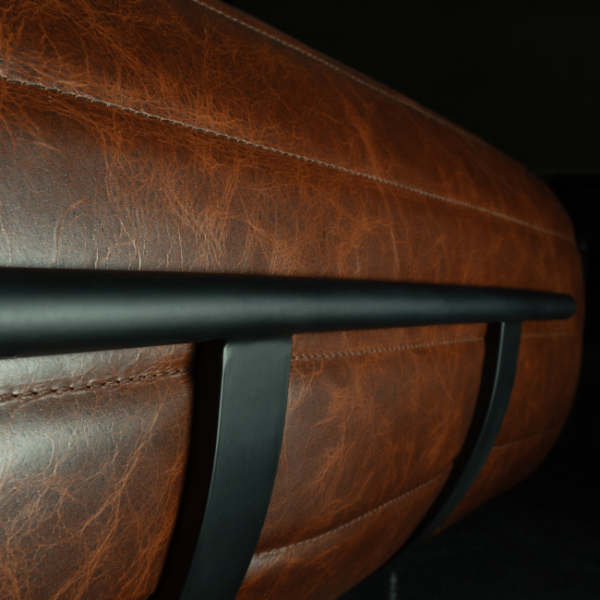 Side view of brown leather backrest with matte black structural frame – modern industrial design for premium UAE interiors. منظر جانبي لمسند ظهر من الجلد البني مع إطار أسود غير لامع – تصميم صناعي عصري للمنازل الفاخرة في الإمارات.