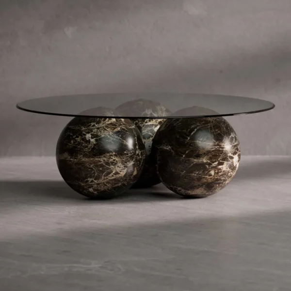Luxury marble coffee table with round glass top and dark brown marble spheres – modern designer furniture by a premium brand in Dubai and Abu Dhabi, UAE