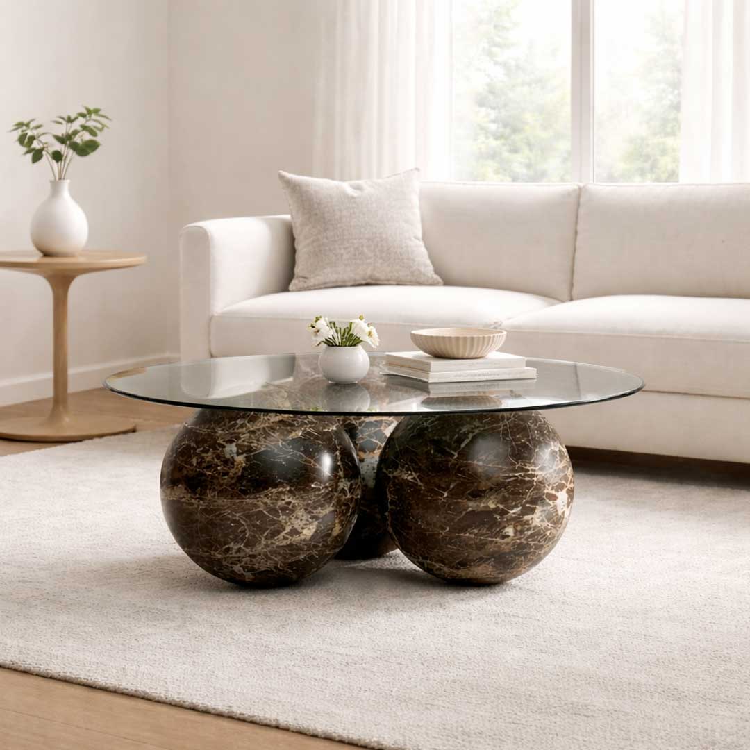Luxury marble coffee table with round glass top and dark brown marble spheres – modern designer furniture by a premium brand in Dubai and Abu Dhabi, UAE