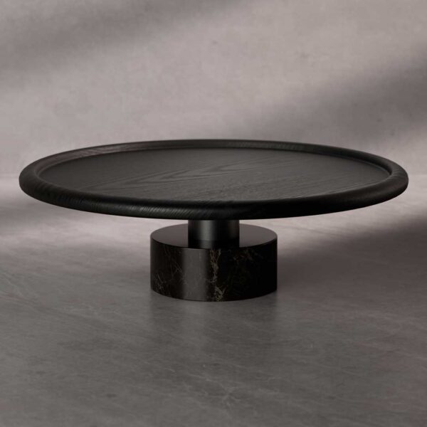 The Nocturne Coffee Table featuring a round black wooden top with a smooth beveled edge, supported by a cylindrical black marble base with subtle veining. A refined modern piece combining natural textures and bold geometry.