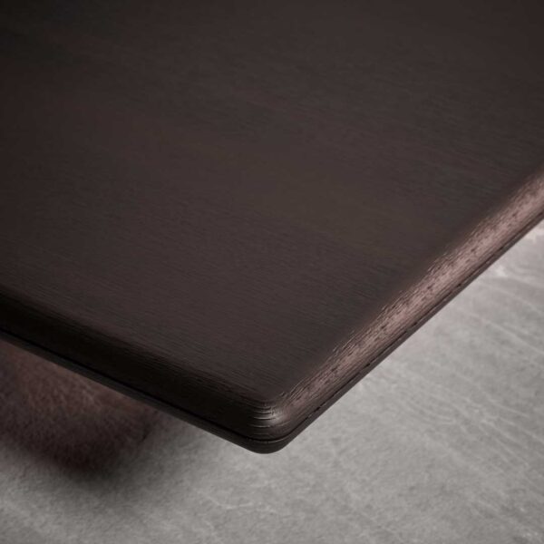 Close-up detail of a luxury designer coffee table featuring a refined dark wood finish and smooth rounded edges, showcasing premium craftsmanship for high-end interiors in Dubai and Abu Dhabi