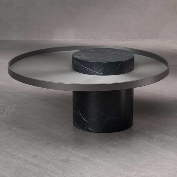 Single Bravura Gemina Coffee Table with a dark marble cylindrical base and a brushed metal circular top. The design showcases clean geometry and luxurious materials.