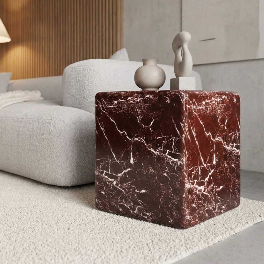 Crimson Sand Side Table made from rich red marble with white natural veining. Its cubic form with soft rounded edges highlights a sculptural, monolithic aesthetic.