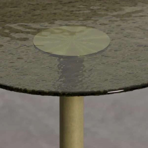 A close-up of the Virella Side Table’s top, showing a dark-tinted glass surface with a rippled, hand-textured finish. The tabletop includes a polished brass inlay at the center, paired with a brushed brass stem beneath it, highlighting the table’s craftsmanship and material contrast.
