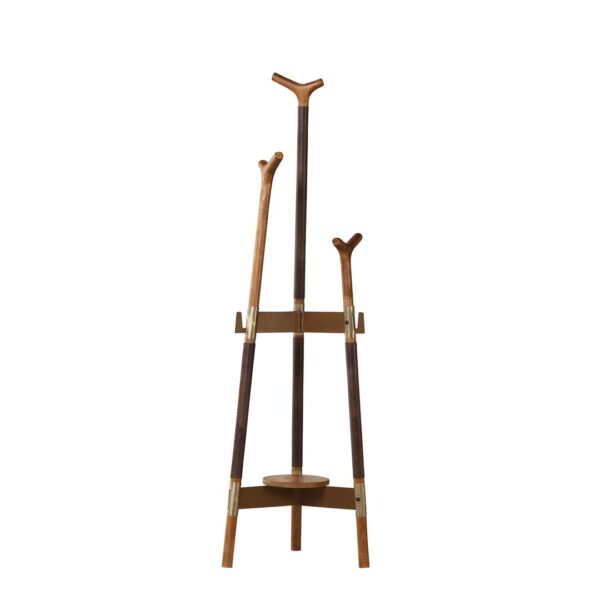 Virello sculptural standing coat hanger with Y-shaped wooden hooks, antique leather-wrapped legs, and brass-accented frame – a luxury accent piece for elegant interiors. علاقة ملابس أرضية فيريلو بتصميم نحتّي، بخطافات خشبية على شكل Y، وأرجل مغلفة بجلد عتيق وهيكل مزين بالنحاس – قطعة فاخرة للديكورات الراقية.