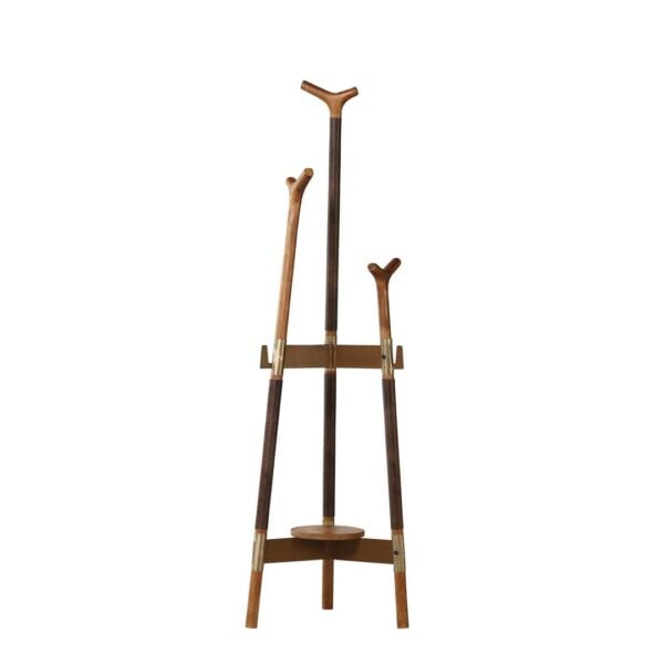 Virello sculptural standing coat hanger with Y-shaped wooden hooks, antique leather-wrapped legs, and brass-accented frame – a luxury accent piece for elegant interiors. علاقة ملابس أرضية فيريلو بتصميم نحتّي، بخطافات خشبية على شكل Y، وأرجل مغلفة بجلد عتيق وهيكل مزين بالنحاس – قطعة فاخرة للديكورات الراقية.