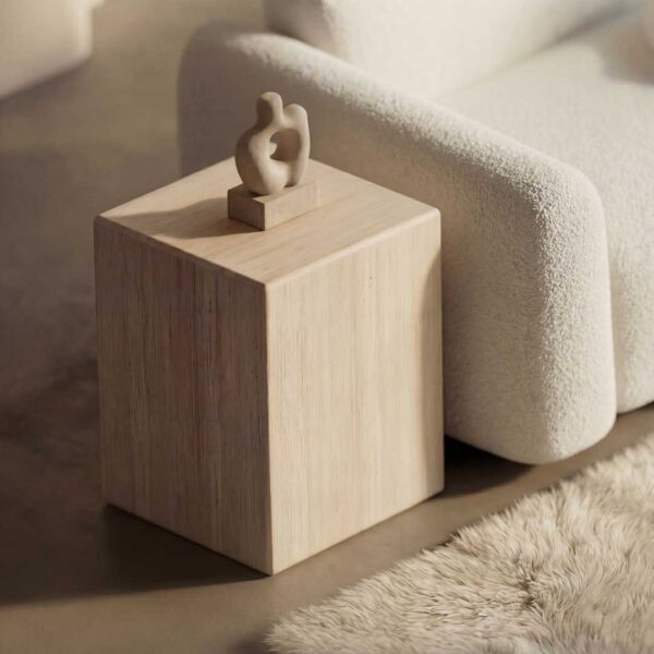 Luxury minimalist side table with a solid stone cube design placed beside a plush modern sofa, highlighting refined textures and sculptural elegance in high-end living room furniture for sophisticated interiors in Dubai and Abu Dhabi, UAE.