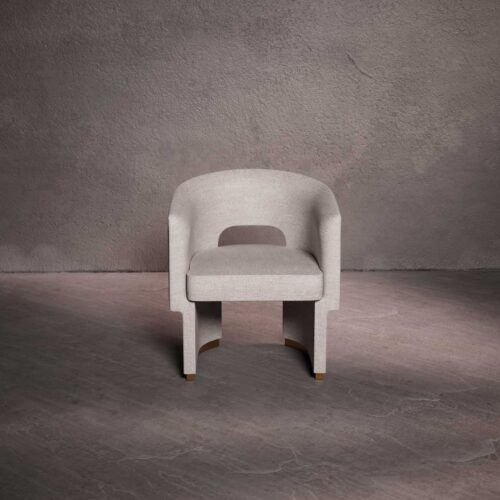 Althea luxury dining chair in light beige fabric, shown from an angled corner view, featuring a curved backrest and sculptural base with warm gold accents – premium UAE furniture كرسي طعام ألفيا الفاخر بقماش بيج فاتح، من منظور زاوية، بظهر منحني وقاعدة نحتية مع لمسات ذهبية دافئة أثاث فاخر في الإمارات