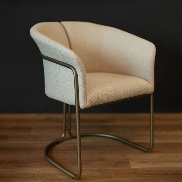 Angled side view of the Alvera Dining Chair showing its sculpted form and brass base, combining elegance and modern design for refined dining spaces.