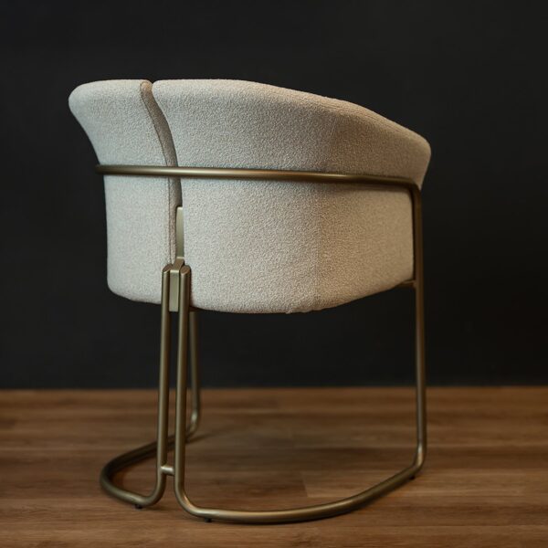 Rear perspective of the Alvera Dining Chair with its split back design and brushed brass frame — a statement piece for luxury dining rooms.