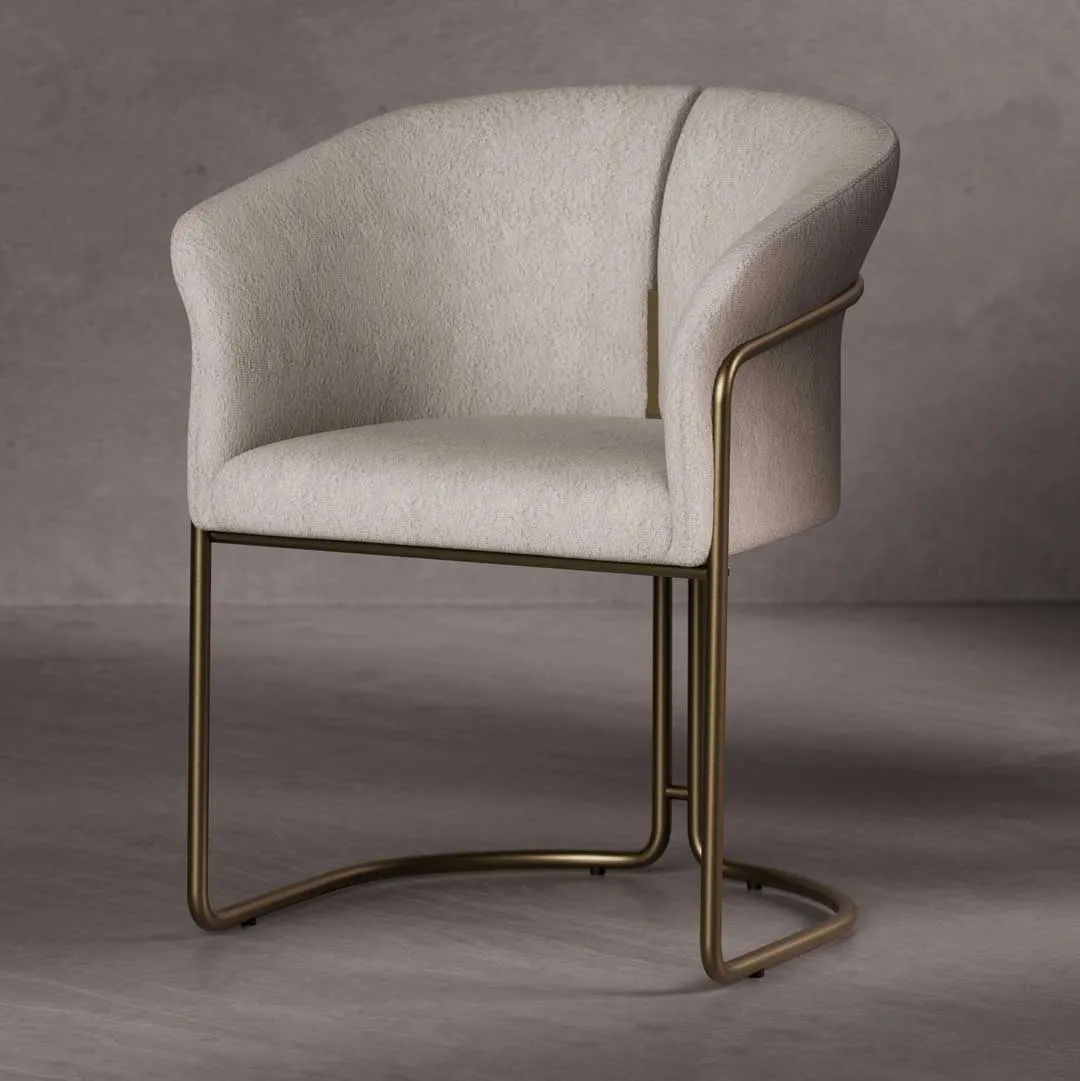 Alvera Dining Chair — a sophisticated modern chair with a curved silhouette, boucle fabric upholstery, and a brushed brass base, designed for elegant dining interiors in Dubai and Abu Dhabi.