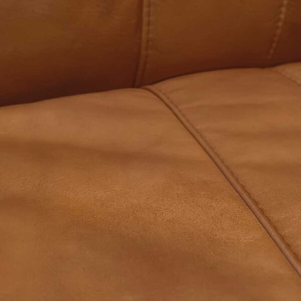 Close-up of the Bon Appétit Dining Chair’s premium tan leather upholstery — showcasing its smooth texture, natural patina, and meticulous stitched finish that defines refined craftsmanship.