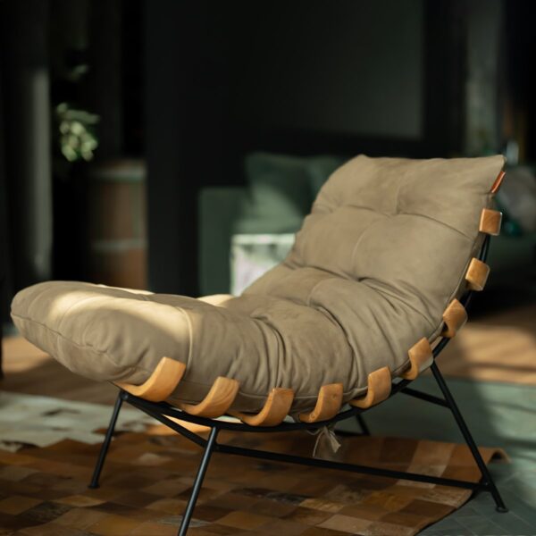 Chancellor Lounge Chair, elegant modern lounge chair in soft beige suede with plush cushioning, supported by a sleek black metal frame and curved wooden accents, styled in a luxury interior setting in Dubai and Abu Dhabi.
