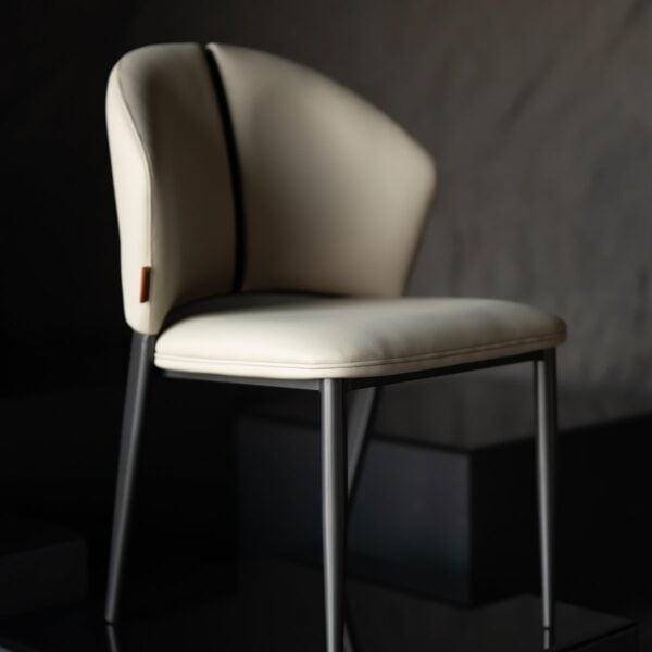 A luxurious off white dining chair in microfiber leather and steel , where comfort meets modern design. كرسي طعام من الجلد المايكروفايبر مع أرجل فولاذية مصقولة بلون أبيض أنيق.