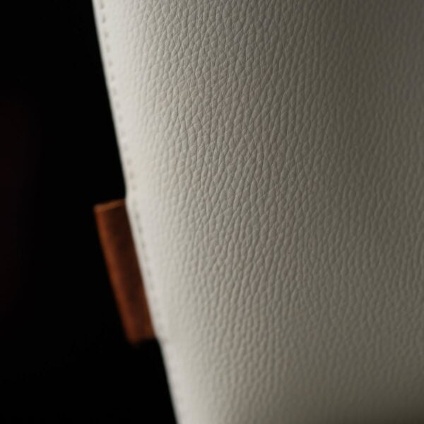 A luxurious off white dining chair in microfiber leather and steel , where comfort meets modern design. كرسي طعام من الجلد المايكروفايبر مع أرجل فولاذية مصقولة بلون أبيض أنيق.