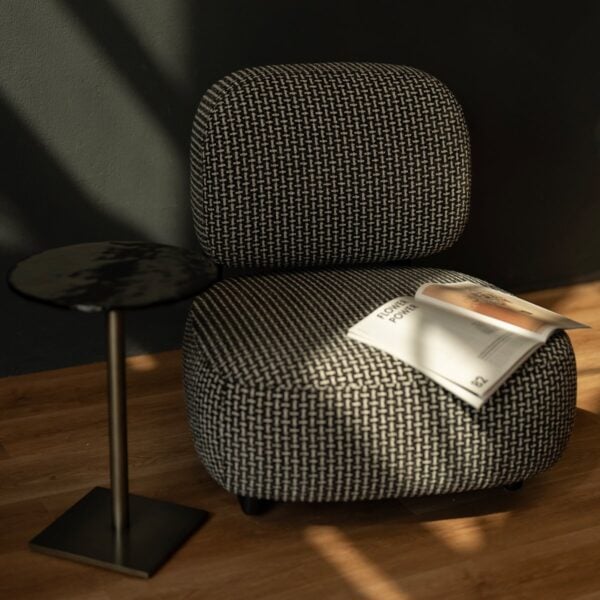 The Selden Lounge Chair placed beside a minimalist black metal side table, bathed in natural light a perfect addition to luxury modern interiors in Dubai and Abu Dhabi