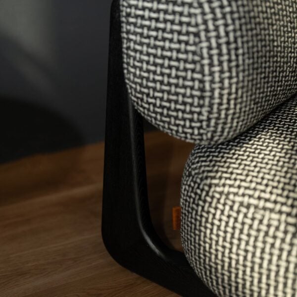 Detail shot of the Selden Lounge Chair’s textured upholstery and open magazine, evoking a cozy and sophisticated lounge atmosphere..
