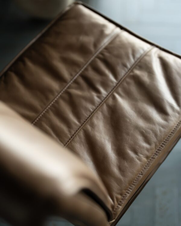 Close-up of the Bon Appétit Dining Chair showcasing its supple tan leather upholstery and fine stitched detailing — highlighting the texture, softness, and craftsmanship of modern luxury furniture.