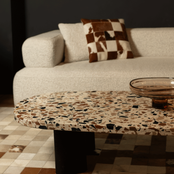 Luxury terrazzo coffee table with modern cream boucle sofa and cowhide cushion in an elegant Dubai living room – premium contemporary furniture UAE.