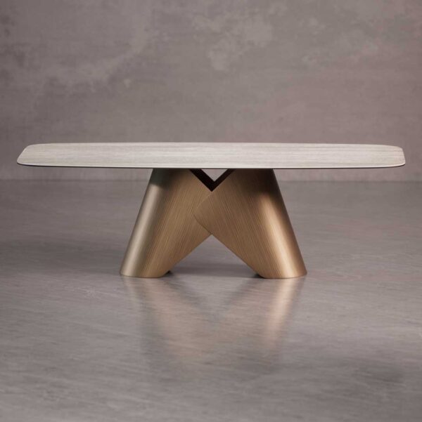 Luxury Knotta Dining Table featuring a travertine-finish ceramic top and sculptural metal base with brushed brass details — designed for modern dining spaces in Dubai and Abu Dhabi.