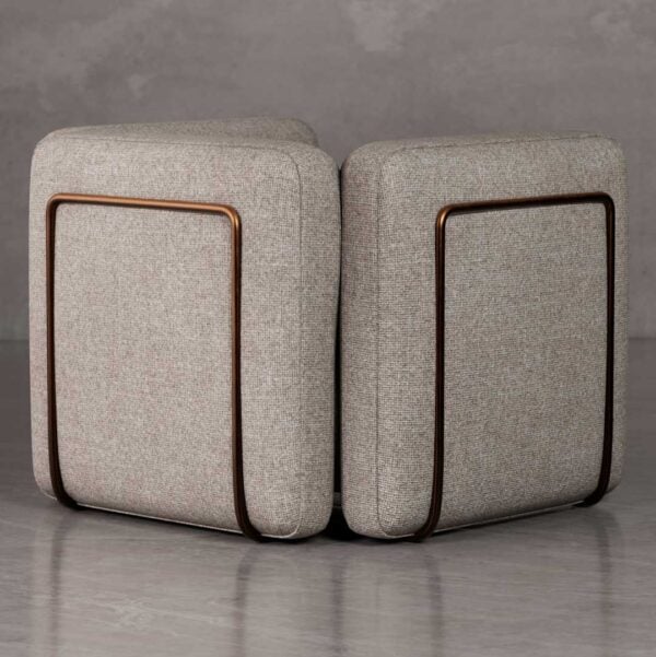 Back view of Cove luxury lounge chair with rounded boxy silhouette and bronze metal accent frame, upholstered in textured fabric for premium developer and hospitality interiors in Dubai and Abu Dhabi UAE.