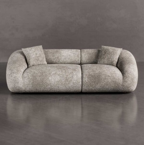 Luxury curved 3-seater sofa with sculptural organic shape and plush rounded cushions placed in a modern minimalist living room with wood coffee table, perfect for upscale interiors in Dubai and Abu Dhabi UAE.