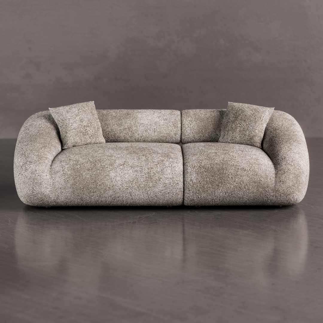 Luxury curved 3-seater sofa with sculptural organic shape and plush rounded cushions placed in a modern minimalist living room with wood coffee table, perfect for upscale interiors in Dubai and Abu Dhabi UAE.